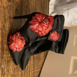 Black satin booties with red roses.